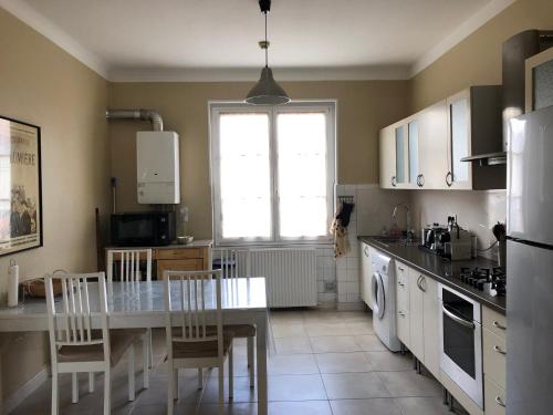 a kitchen with a table and a table and chairs at La California in Oullins