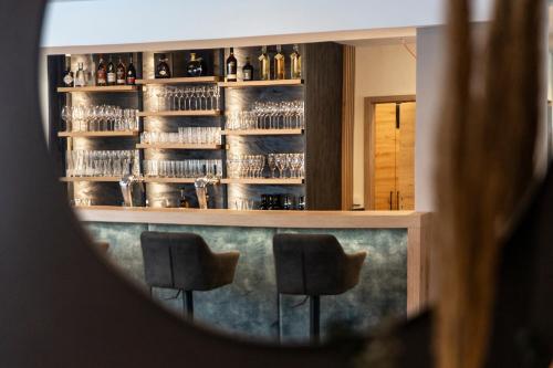 a reflection of a bar with two chairs in a mirror at Stadthotel Lichtenfels in Lichtenfels
