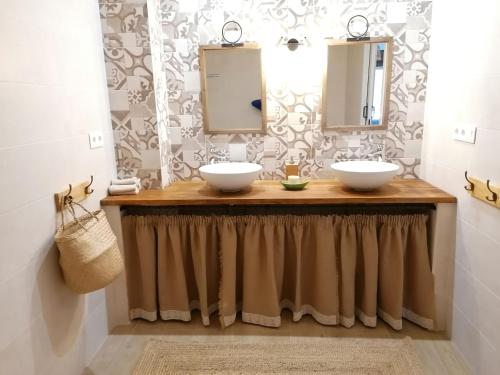 een badkamer met 2 wastafels en 2 spiegels bij Cortijo Samadhi in Lanjarón