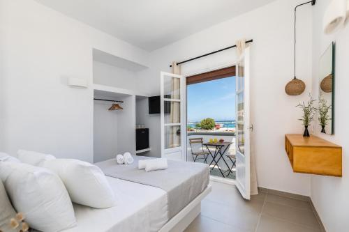 a bedroom with a bed and a view of the ocean at Uncle John's Guesthouse in Skopelos Town