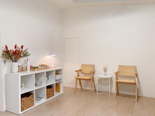 a living room with two chairs and a table at Cozy Homestay in Tainan