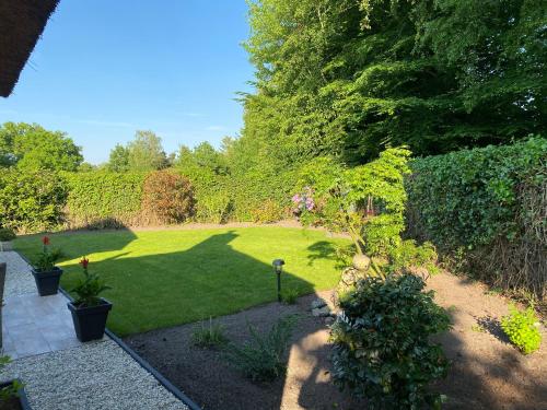 a garden with green grass and bushes and trees at Aaltje’s Hoeve in Ermelo