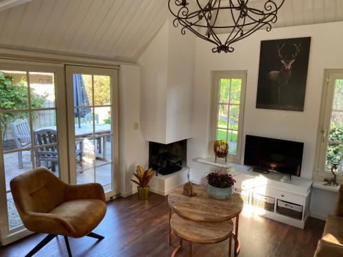 a living room with a chair and a fireplace at Aaltje’s Hoeve in Ermelo