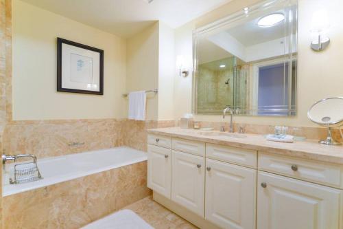 a bathroom with a tub and a sink and a mirror at Live the Miami Experience in an Exclusive Condo 4S in Miami