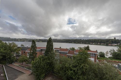 a view of a building with a lake in the background at Traumhafte Ferienwohnung in Ratzeburg