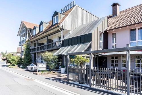 ein Gebäude auf einer Straße mit einem Zaun in der Unterkunft Hotel in den Herrnwiesen in Wertheim