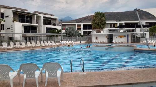 a large swimming pool with chairs and people in it at Apartasol Santa Fe Oficial in Santa Fe de Antioquia