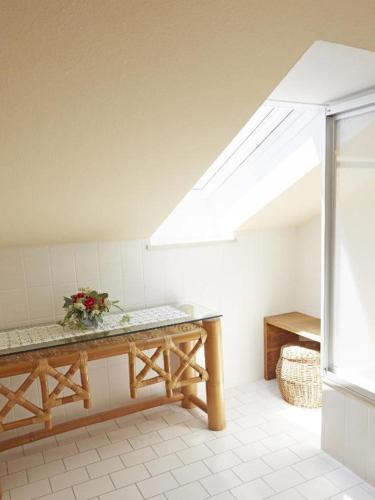a room with a skylight and a table with flowers on it at Gästehaus Bauer am Golfplatz in Prien am Chiemsee