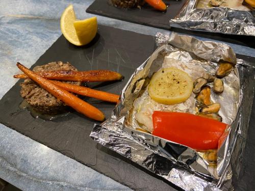 un plateau de nourriture avec de la viande et des légumes sur une feuille dans l'établissement Jacuzzi privé Chambre et table d hotes, à Vauvert
