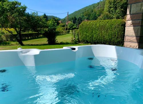 a swimming pool with blue water in a yard at Le Gîte de l'Ecureuil in Sturzelbronn