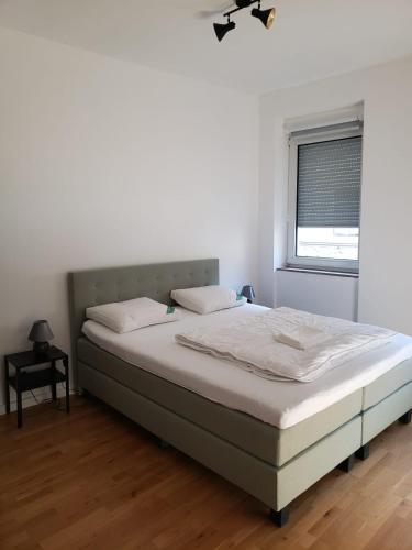 a bed in a white room with a window at Haus Alte Metzgerei - im Herzen der Altstadt in Zell an der Mosel