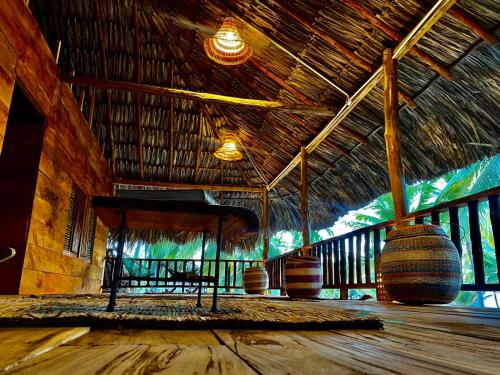 a room with a bench and a straw roof at Playa Jaguar - Beach Club in Moñitos