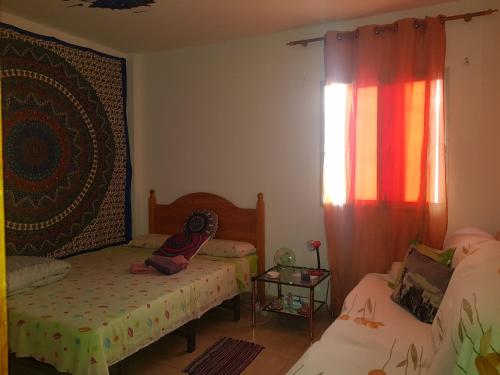 um pequeno quarto com 2 camas e uma janela em laurainu em Puerto del Rosario