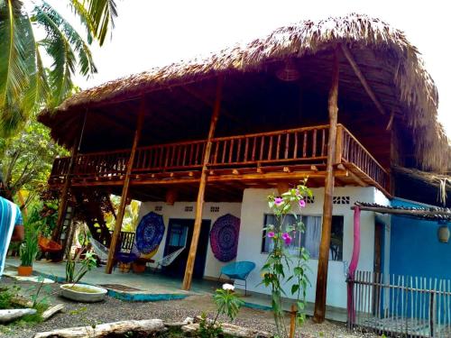 a blue and white house with a thatched roof at Playa Jaguar - Beach Club in Moñitos