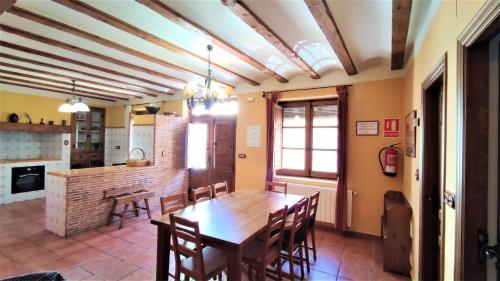kuchnia i jadalnia z drewnianym stołem i krzesłami w obiekcie Casa Rural Carcelen w mieście Carcelén