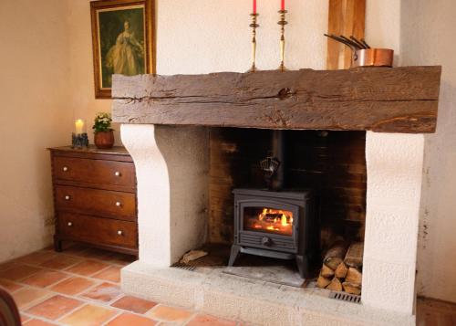 a fireplace with a fire in it in a room at La Bastide Portoly Gîte "Les Deux Cèdres" in Penne-dʼAgenais