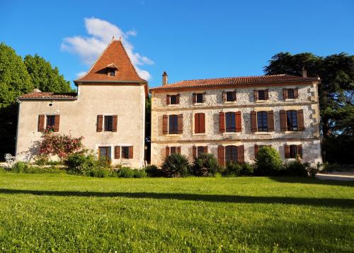 an old building with a tower on top of a field at La Bastide Portoly Gîte "Les Deux Cèdres" in Penne-dʼAgenais