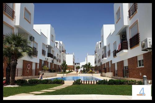 a building with a swimming pool in front of it at HOME4U - Fantastic 2 bedroom apartment, with pool in Cabanas de Tavira