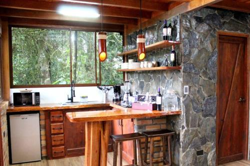 a kitchen with a counter and a stone wall at Luxury cabin surrounded by nature in Baeza