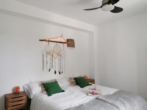 a bedroom with a large white bed with green pillows at Cortijo Samadhi in Lanjarón