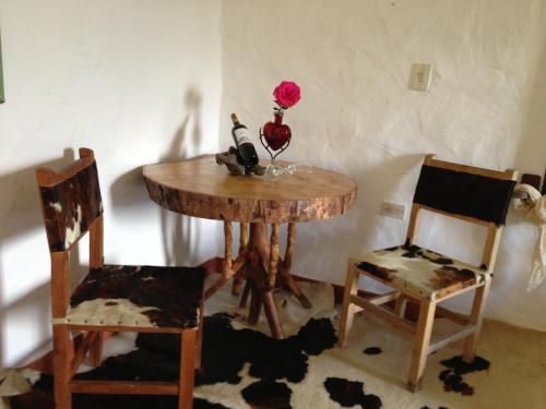 a table with two chairs and a wine bottle on it at Akawanka Lodge in San Agustín