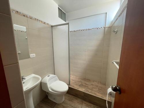 a bathroom with a toilet and a sink and a shower at Aeropuerto Hotel in Ayacucho