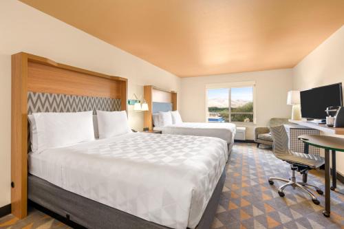 a hotel room with two beds and a desk at Holiday Inn Yakima by IHG in Yakima