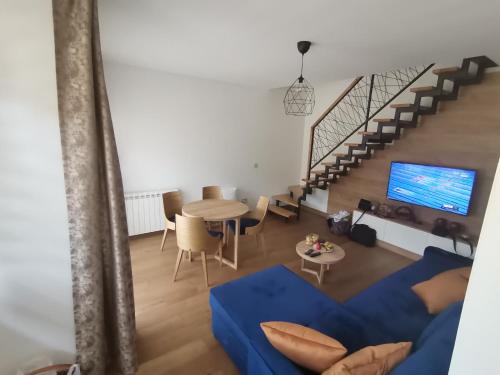 a living room with a blue couch and a table at V&Dj in Čajetina