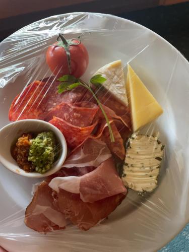 a plate of food with meat cheese and other foods at Arrowtown House Boutique Hotel in Arrowtown