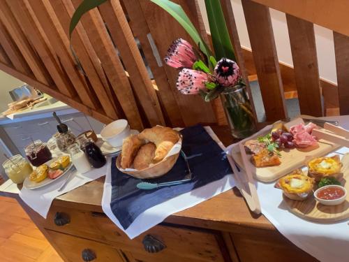 a table with a plate of bread and other foods at Arrowtown House Boutique Hotel in Arrowtown