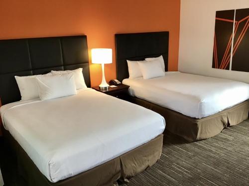 a hotel room with two beds and a lamp at Howard Johnson by Wyndham Spokane in Spokane