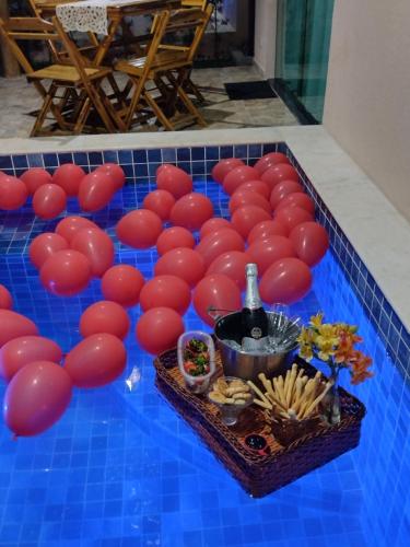 a bunch of red balloons on top of a blue tiled floor at Bellíssimo Villaggio in Porto De Galinhas