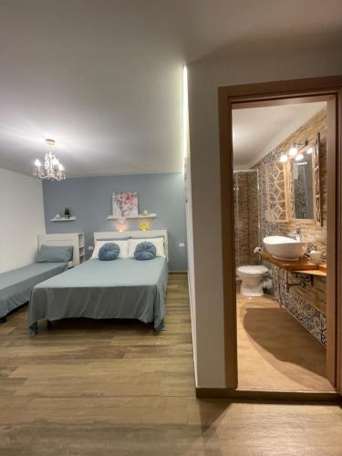 um quarto com uma cama e uma casa de banho com um lavatório em B&B Il Gigante em Agrigento