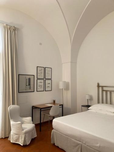 a bedroom with a bed and a table and chairs at Gli Archi e le Stelle in Brindisi