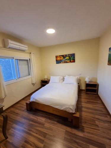 Odem的住宿－הצימר של אורנה，卧室配有白色的床和窗户。
