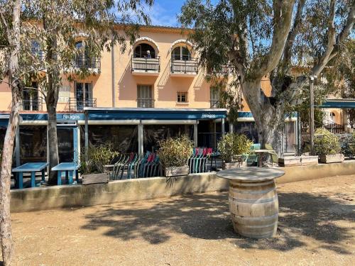 a building with chairs and a barrel in front of it at Latitudes 43 in Porquerolles