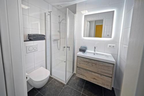 a white bathroom with a toilet and a shower at Hotel Abdijhof Thorn in Thorn