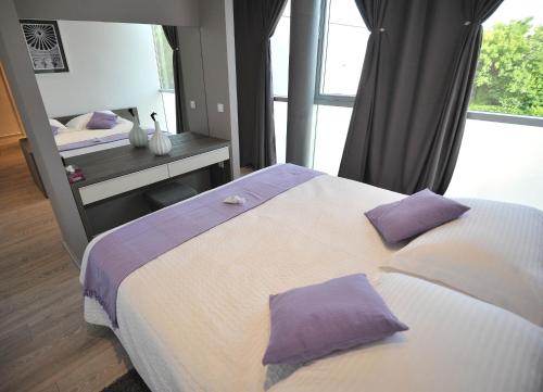 a bedroom with a large bed with purple pillows at Apartments & Rooms Lavandula Exclusive in Zadar