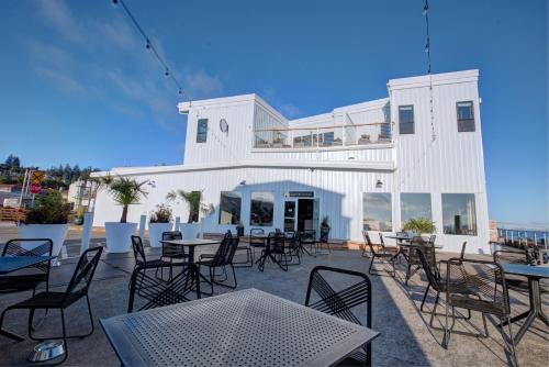 アストリアにあるBowline Hotelの建物の前のテーブルと椅子のあるパティオ