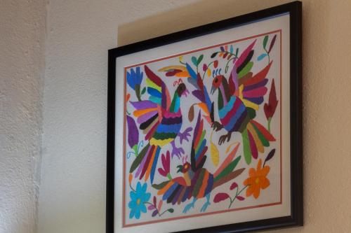 a picture of a painting of birds on a wall at Casa Maricela B&B in San Miguel de Allende
