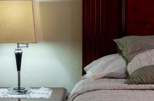 a lamp sitting on a table next to a bed at Casa Maricela B&B in San Miguel de Allende
