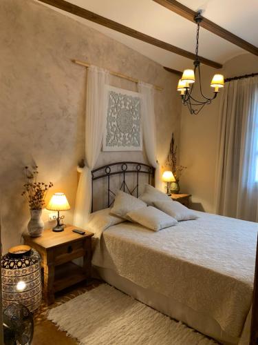 a bedroom with a large bed and two lamps at Casa Rural Valle del Palancia in Castellnovo