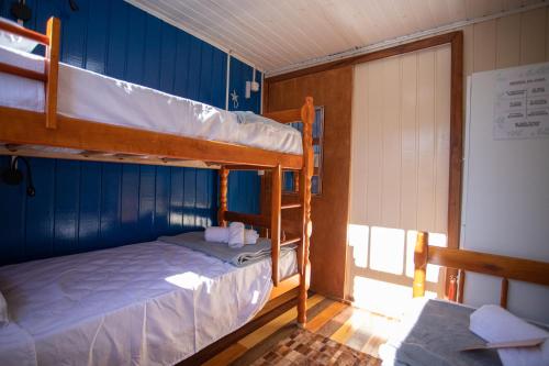 2 Etagenbetten in einem Zimmer mit Fenster in der Unterkunft Hostel Butiá in Laguna