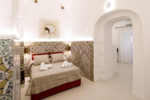 a bedroom with a bed and a mirror on the wall at Qasar Luxury Suite - in Capri's Piazzetta in Capri
