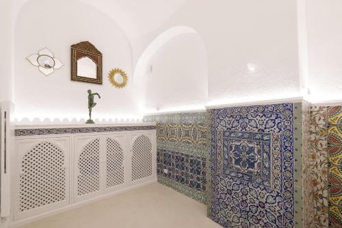Habitación con azulejos azules y blancos en las paredes. en Qasar Luxury Suite - in Capri's Piazzetta en Capri