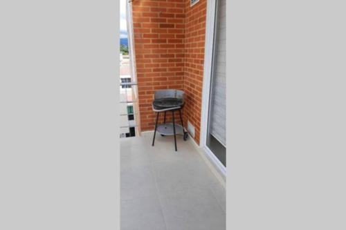 a stool sitting on a balcony next to a brick wall at Penthouse SPA Jacuzzi y Sauna Privado in La Mesa