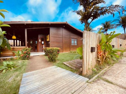 a house with a wooden walkway in front of it at Pousada Ilha Bella in Fernando de Noronha