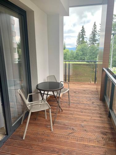 a patio with a table and chairs on a balcony at ARMERIA 4/1 in Štrbské Pleso