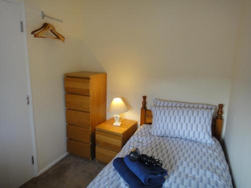 a bedroom with a bed and a dresser and a lamp at 6 Berth House, 2 Bthrm, 2 WC, Parking, Washer, Dryer in Corby