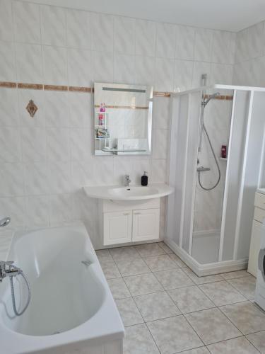 a white bathroom with a sink and a shower at Ferienwohnung Uferblick in Plaue